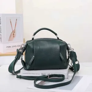 Dark green genuine leather handbag detail, featuring durable metal zippers and strap rings.