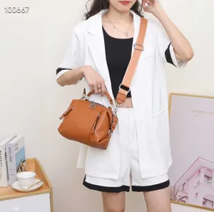 Detail view of stylish brown genuine leather top-handle crossbody bag for daily women.