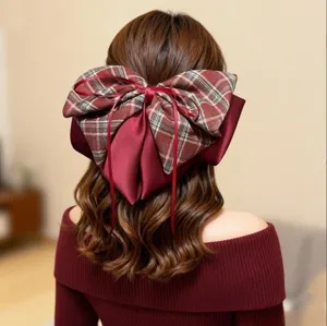 Detailaufnahme einer großen karierten Satin-Schleifen-Haarspange mit fließenden Bändern.
