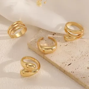 Close-up of stylish gold ring set, featuring unique geometric designs and polished finish.