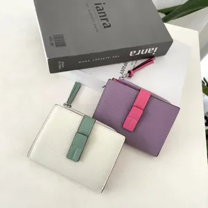 Detail view of stylish color block short leather wallet featuring snap and zip coin pocket.