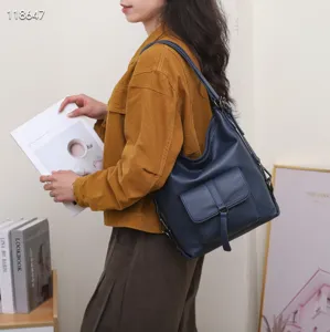 Vue détaillée d'un sac à dos et sac à bandoulière en cuir véritable bleu foncé.