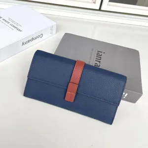 Primo piano portafoglio lungo blu con cinturino a contrasto rosso, pelle pregiata, vani carte.