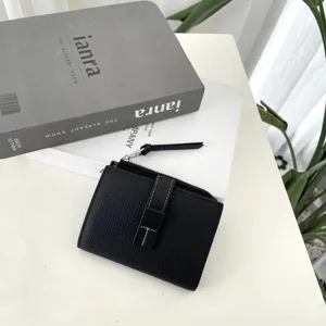 Black genuine leather short women wallet with secure zipper closure and stylish buckle detail.