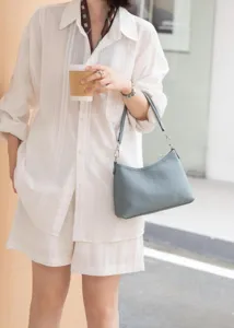 Close-up view of the blue leather underarm bag worn by a model in daily commute style.