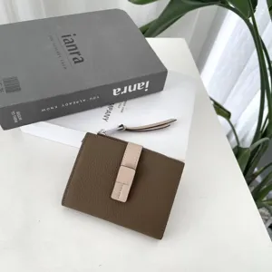 Close-up detail of brown color-block leather women wallet with snap closure and zipper.