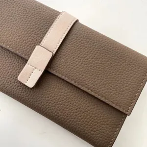 Vista dettagliata del portafoglio lungo in pelle da donna con cinturino a contrasto e tasche.