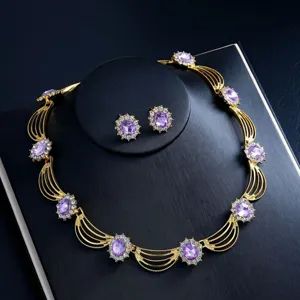 Detailed close-up of luxury gold-plated purple crystal gemstone necklace and earrings set.