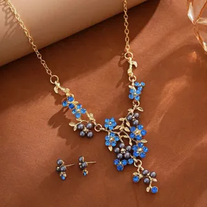 Stunning gold-tone pearl and blue rhinestone floral necklace earrings set for bridal wear.