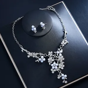 Close-up detail of silver floral pearl rhinestone necklace and matching earrings set.