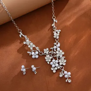 Close-up detail of silver-tone pearl and rhinestone floral necklace and matching earrings set.