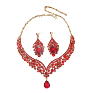 Set di gioielli collana orecchini strass rosso oro da sposa per festa elegante.