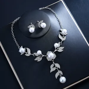 Vista detallada del conjunto de collar y pendientes con perlas y estrases, diseño floral brillante.