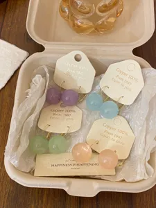 Vue détaillée de boucles d'oreilles sphériques colorées, emballage style dopamine.