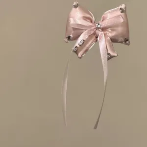 Roze satijnstrik haarband versierd met fonkelende strass steentjes en mooie haaraccessoires.