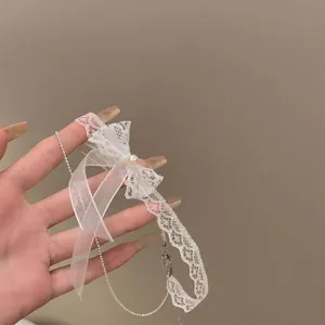Detalle del primer plano de collar choker de encaje blanco con lazo perla fino.