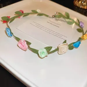 Primer plano detallado del collar gargantilla de tela con rosas de colores y hojas verdes.