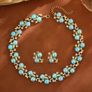 Vue détaillée de l'ensemble collier et boucles d'oreilles perles turquoise et or.