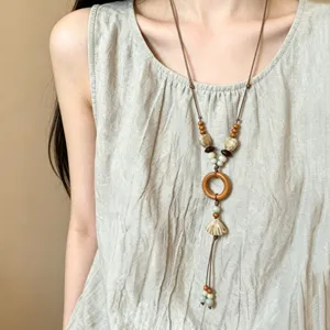 Detail shot of the long ethnic wooden bead and shell necklace showcasing intricate craftsmanship.