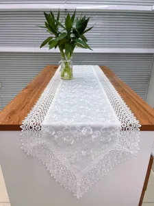 Witte kanten tafelloper met mooi bloemenborduurwerk, ideaal voor een stijlvolle inrichting.