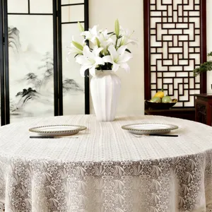 Detailed shot of the elegant lace embroidered round tablecloth, showcasing delicate hollow pattern.