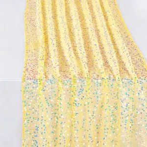 Yellow iridescent sequin fabric detail, shimmering sparkle embroidery mesh material close up