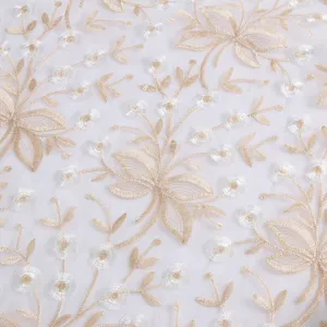 Organdy embroidered fabric detail featuring gold and silver floral vines for elegant table decor.