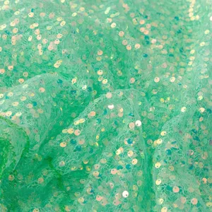 Close-up of green iridescent sequin mesh fabric, perfect for dresses and wedding crafts.