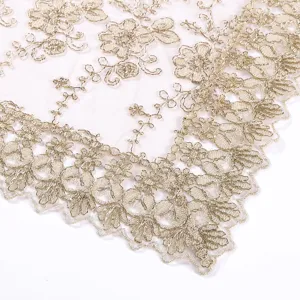 Detalle de mantel de encaje bordado en oro de lujo nórdico, elegante diseño floral.