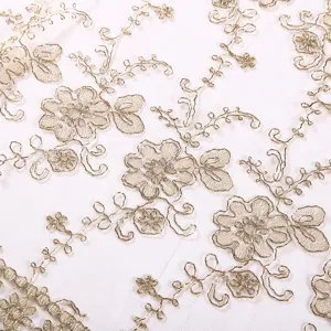 Detalle de mantel de encaje bordado dorado, tela de malla transparente con flores, decor.
