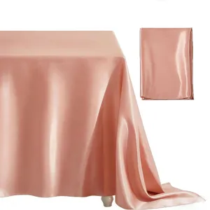 Detail view of pink satin rectangular tablecloth, elegant smooth fabric texture for wedding decor