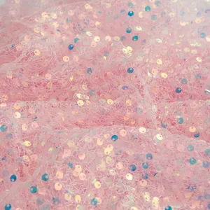 Dettaglio di tessuto in tulle con paillettes a sirena rosa per feste e decorazioni.