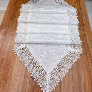 Witte dubbellaagse kanttafelloper met prachtig borduurwerk voor huiselijke tafeldecor.