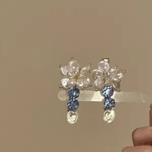 Vista de detalle de la pinza para el pelo con flor de perla y colgantes de cristal azul.