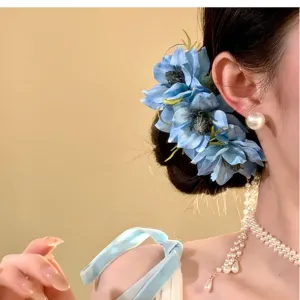 Vista dettagliata dell'elegante fermaglio per capelli floreale blu e accessori di perle raffinati.