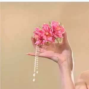 Fermaglio per capelli con fiore rosa e nappe di perle, primo piano per vacanze estive.