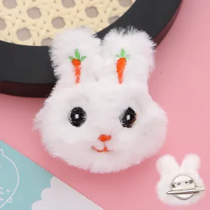 Dettaglio del fermaglio per capelli con coniglietto di peluche, ricamo di carote e spilla.