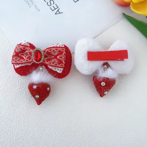 Detail van rood-witte pluche haarspelden, perfect voor traditionele feestelijke kinderoutfits.