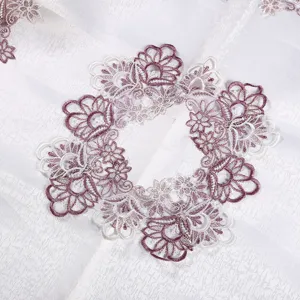 Close-up of Nordic luxury white tablecloth with elegant purple and white floral lace embroidery.