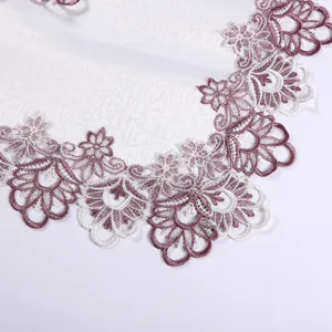 Close up view of luxury Nordic tablecloth with elegant purple and white lace floral embroidery edge.