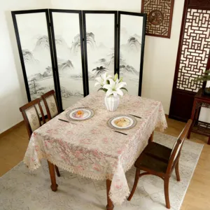 Detailed view of European floral lace tablecloth on dining table, elegant fabric design.