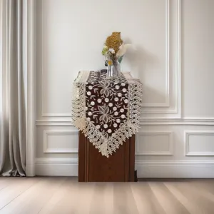 Detailed view of American style embroidered lace table runner with vintage floral design.
