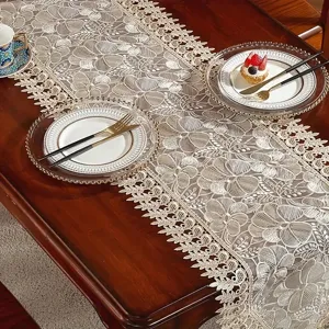 Exquisites Detail des bestickten Spitzentischläufers, elegantes Blumenmuster für Esszimmer.