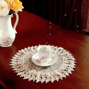 Detailed view of elegant white lace embroidery round tablecloth, vintage floral home decor.