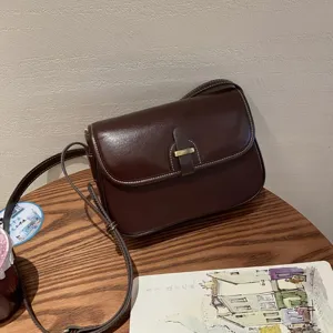 Dunkelbraune Vintage Leder Umhängetasche mit Metallverschluss und Kontrastnähten Detail.