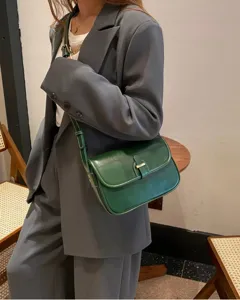 Detailansicht der dunkelgrünen Ledertasche mit feinen Nähten und elegantem Metallverschluss.