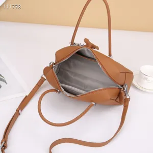 Genuine leather brown boston handbag with top handle and crossbody strap, spacious interior.