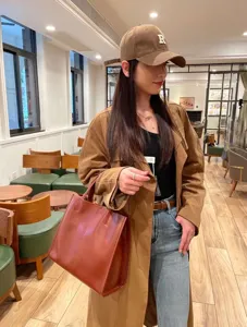 Detailed view of the brown leather tote bag showcasing its large capacity and sleek design.