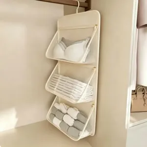 Organizador colgante de pared para armario con tres bolsillos de malla para almacenamiento.