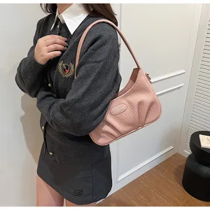 Stylish pink pleated underarm bag detail view, showcasing soft texture and compact design for daily wear.